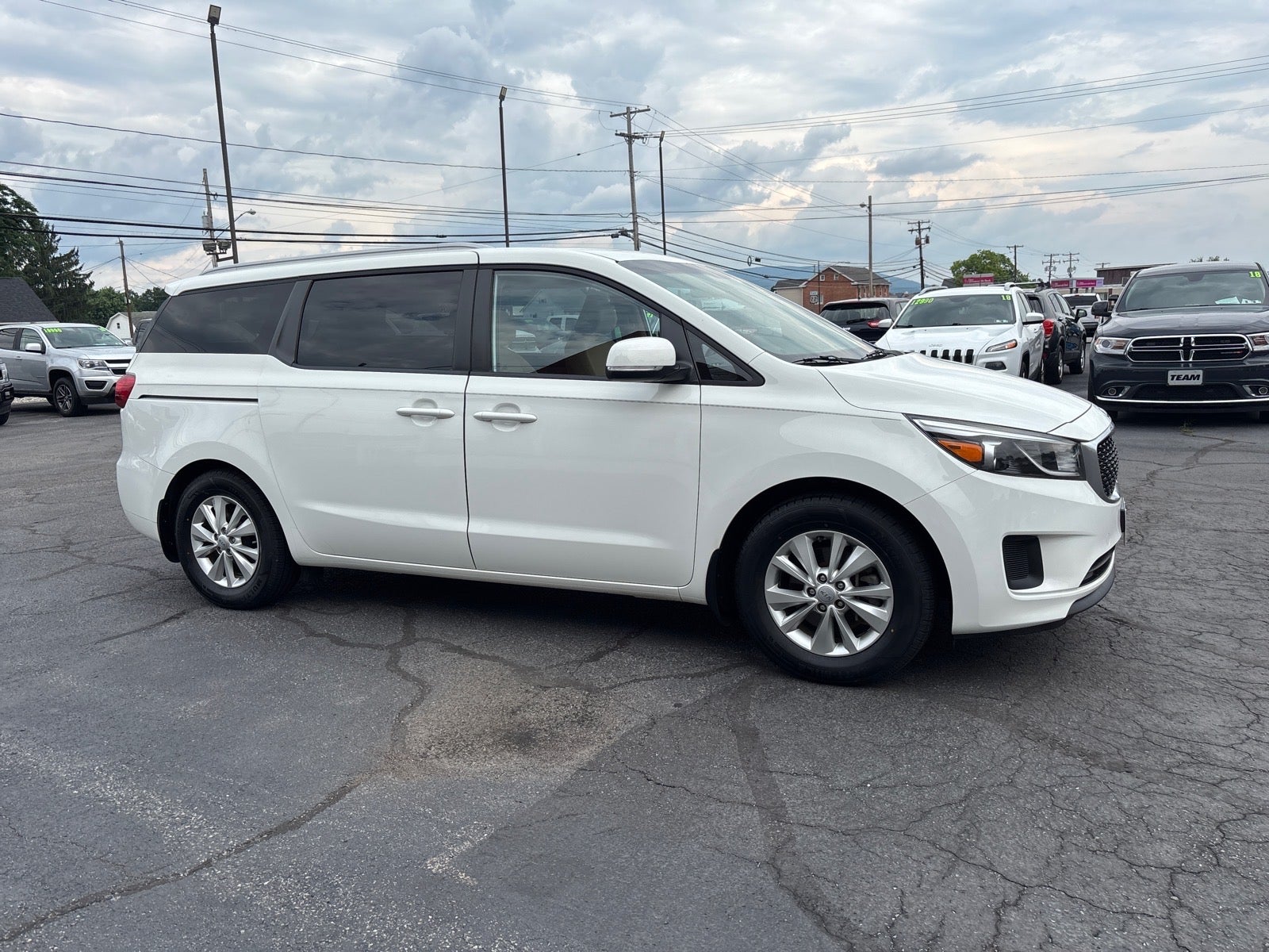 2016 Kia Sedona LX in Clear White — front three-quarter view